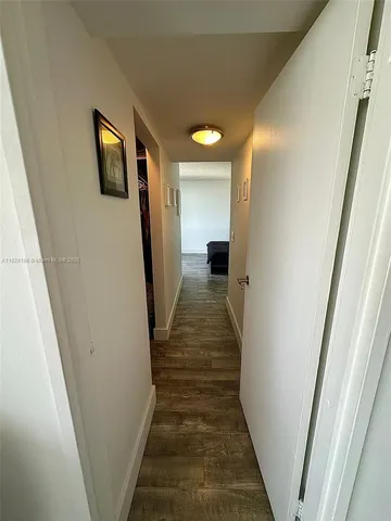 a view of a hallway with wooden floor and stairs