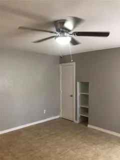 an empty room with closet and a chandelier fan