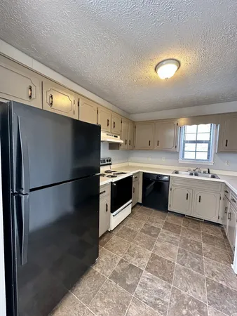 a large white kitchen with a refrigerator a sink dishwasher and a stove with a dishwasher