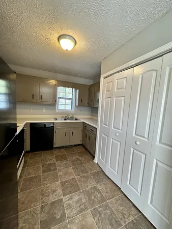 a kitchen with a sink a stove top oven cabinets and a refrigerator
