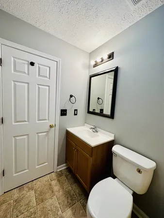 a bathroom with a toilet a sink and mirror