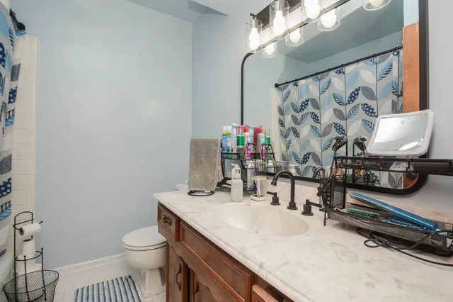 a bathroom with a granite countertop sink a toilet and a mirror