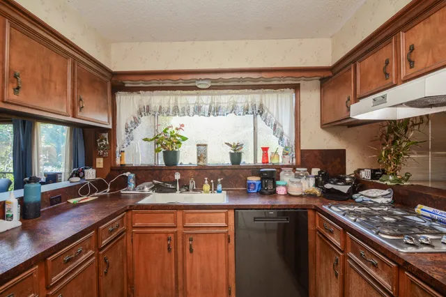 a kitchen with stainless steel appliances granite countertop a sink stove and cabinets