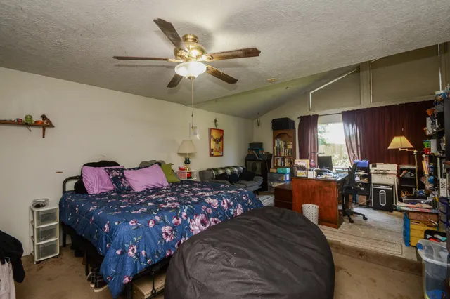 a bedroom with a bed a chandelier and a dresser