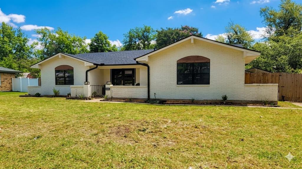 White painted brick exterior with a dark shingle roof and black-framed windows