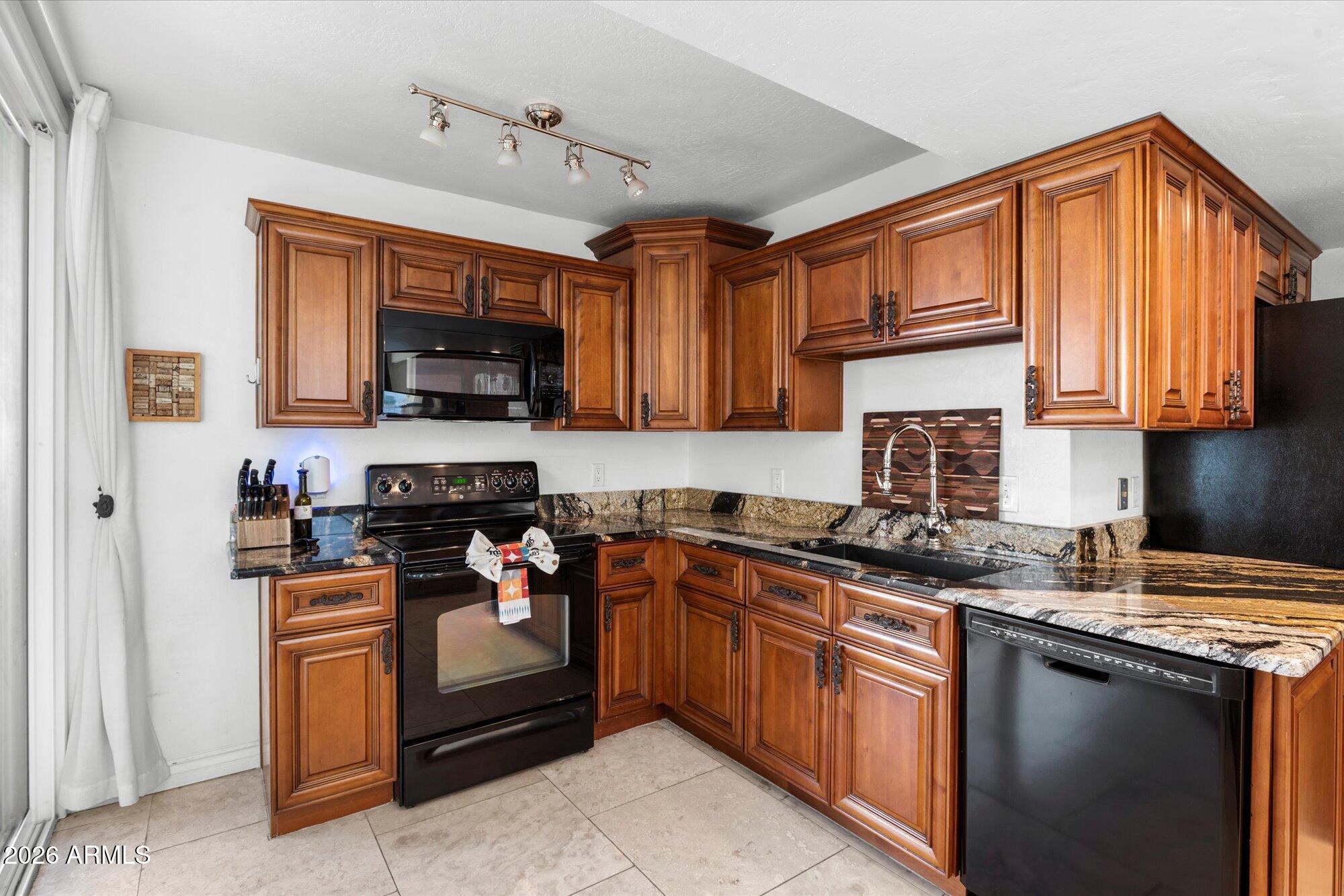 7005 North Barbados Place Phoenix, AZ 85021 - Photo 17 of 42 a kitchen with stainless steel appliances granite countertop a stove sink microwave and cabinets