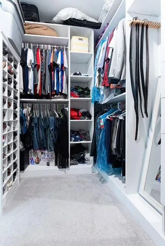 a view of walk in closet with clothes