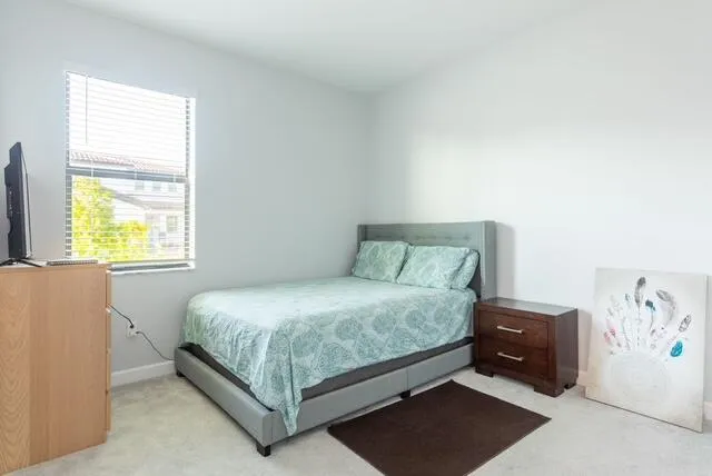 a bed sitting in a bedroom next to a window