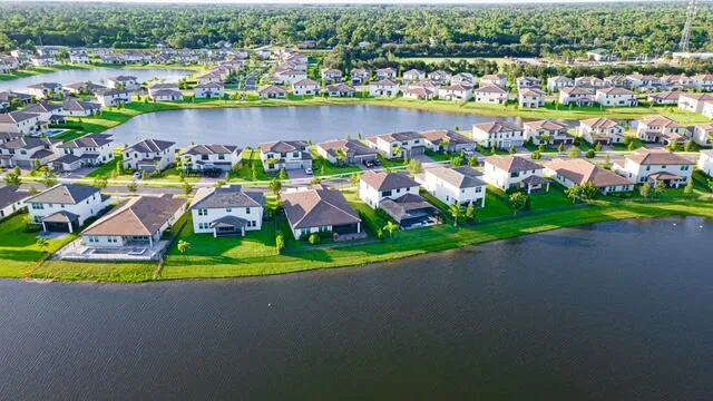 an aerial view of a house with a garden and lake view
