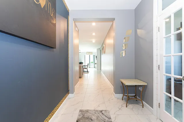 a view of a hallway with furniture and a window