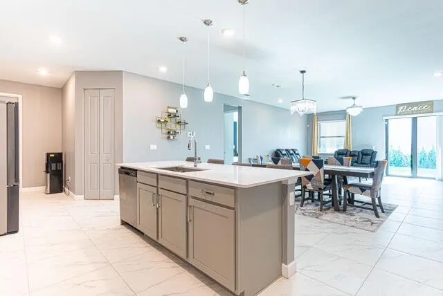 a large kitchen with kitchen island a sink a counter space and a dining table view