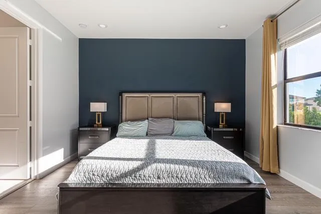 a bedroom with a large bed and wooden floor