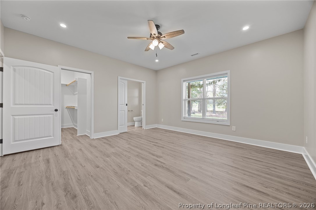 432 Pearidge Road Willow Spring, NC 27592 - Photo 26 of 47 an empty room with wooden floor ceiling fan and windows