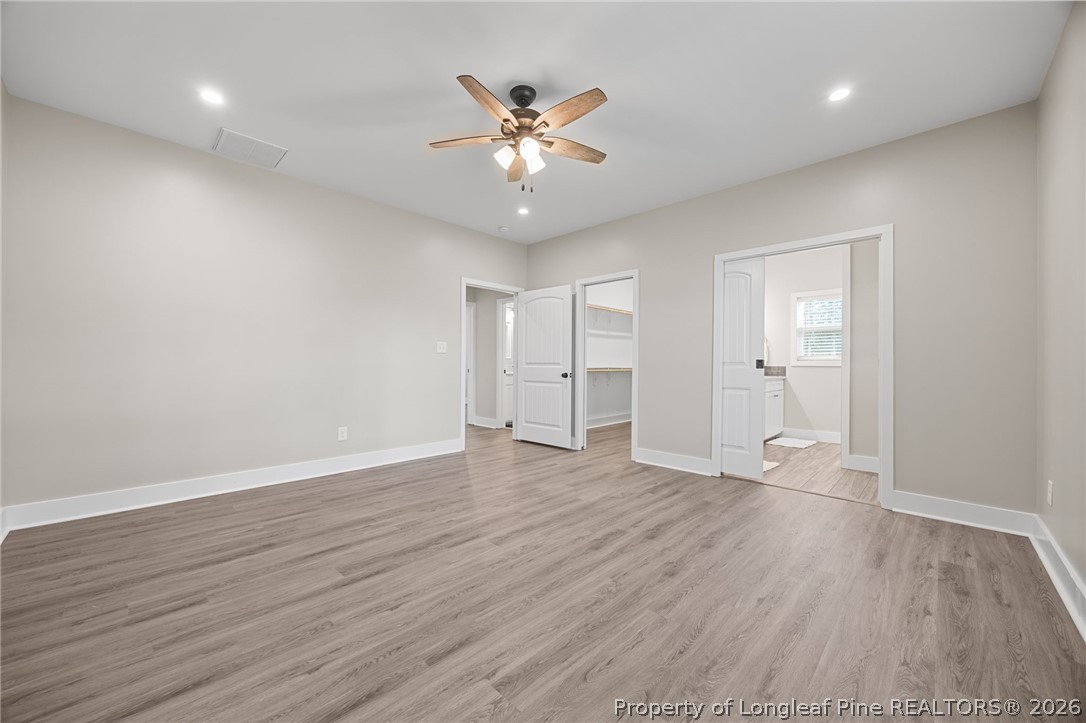 432 Pearidge Road Willow Spring, NC 27592 - Photo 27 of 47 a view of an empty room with wooden floor and a ceiling fan