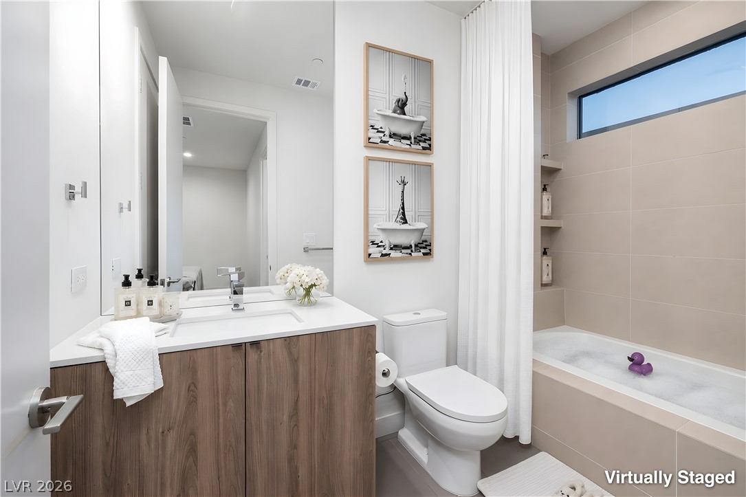 25 Falling Ridge Lane Henderson, NV 89011 - Photo 31 of 48 A well-lit bathroom with a vanity and modern fixtures offers a relaxing soak in the tub.
