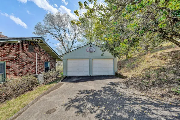 a view of a house with a yard and large tree