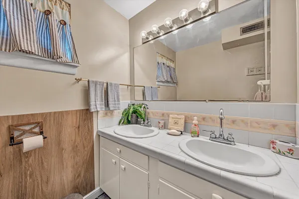 a bathroom with a sink a mirror a toilet and shower curtain