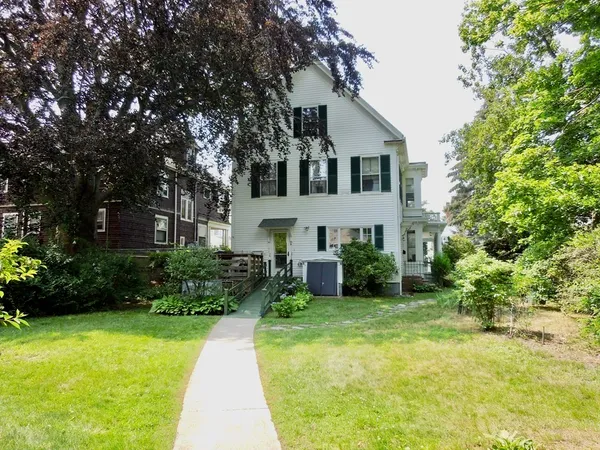 a view of house with a yard and potted plants