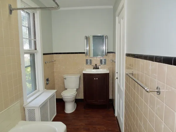 a bathroom with a toilet sink and a mirror