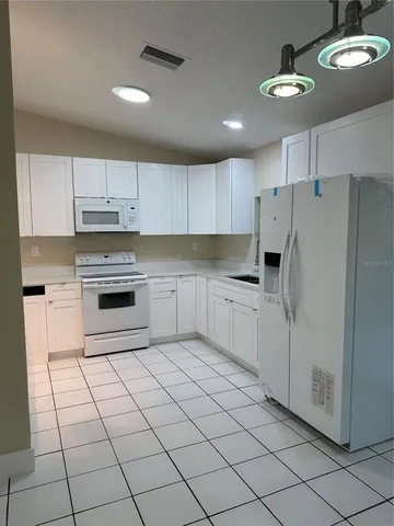 a kitchen with cabinets and white stainless steel appliances