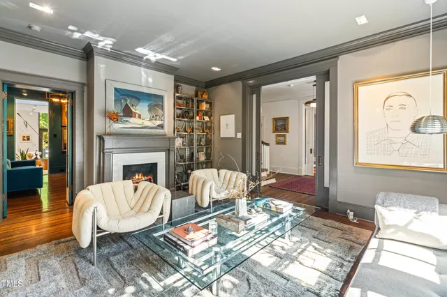 a living room with furniture fireplace and a large window