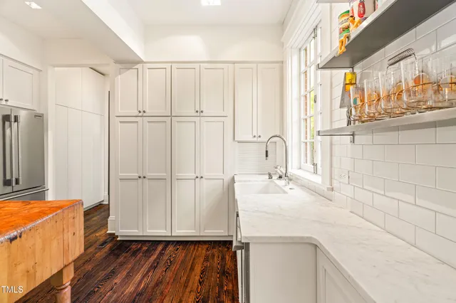 a view of a kitchen with a sink and dishwasher with wooden floor