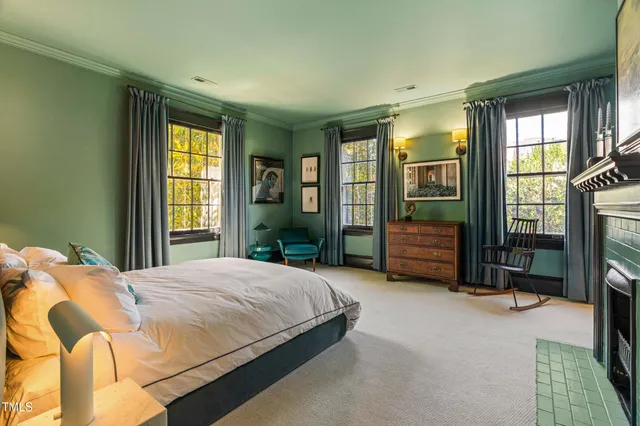 a bedroom with a bed mirror and windows