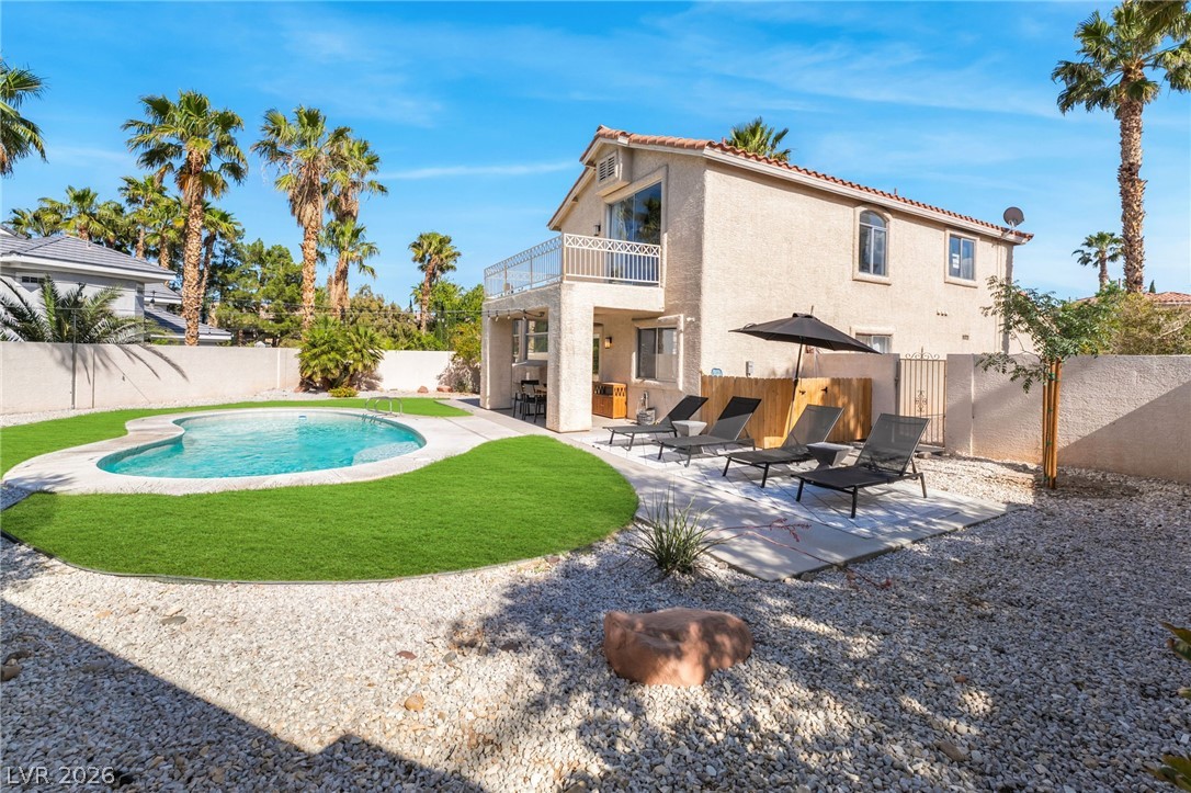 1941 Ivy Point Lane Las Vegas, NV 89134 - Photo 18 of 21 An inviting backyard oasis awaits with a sparkling pool, ample patio space, and mature palm trees.
