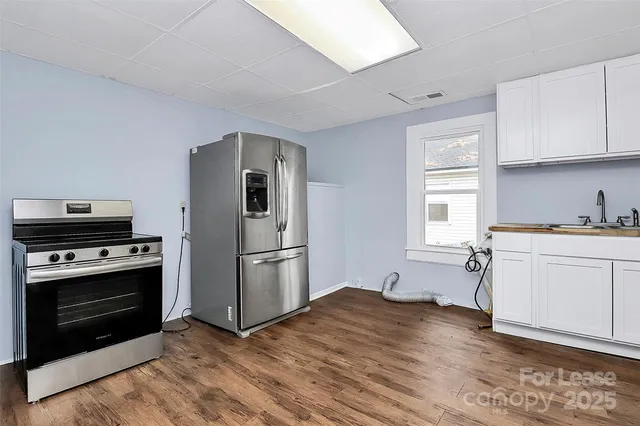 a kitchen with a refrigerator stove and white cabinets