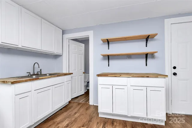 a kitchen with white cabinets and sink