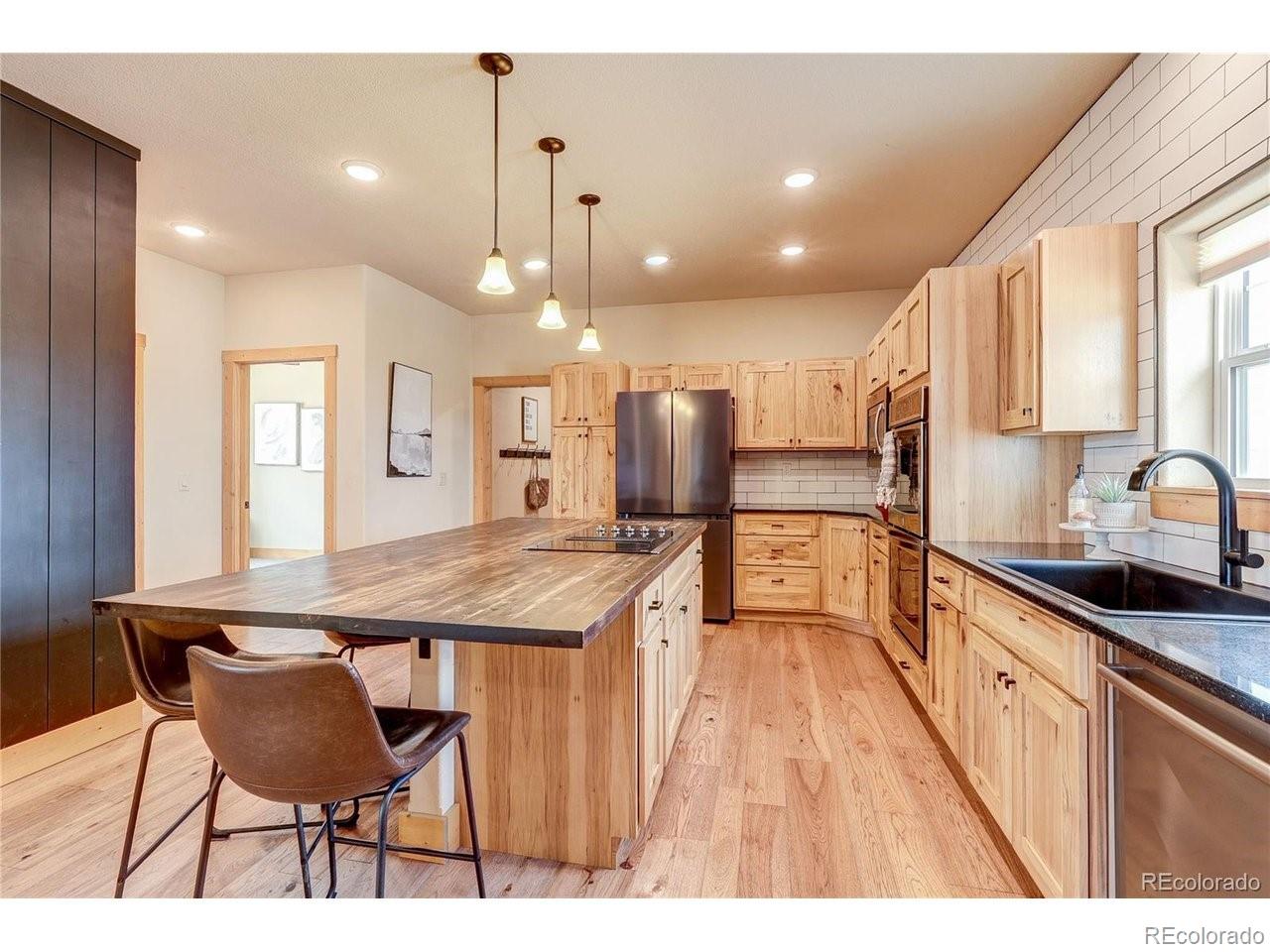 18298 Romar Rnch Road Carr, CO 80612 - Photo 17 of 49 a kitchen with stainless steel appliances kitchen island granite countertop a sink and cabinets
