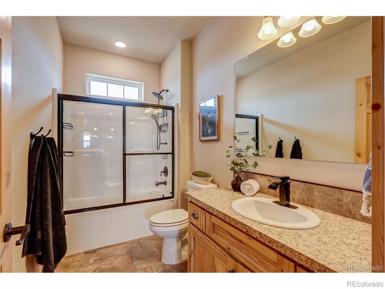 18298 Romar Rnch Road Carr, CO 80612 - Photo 24 of 49 a bathroom with a sink toilet a mirror and shower