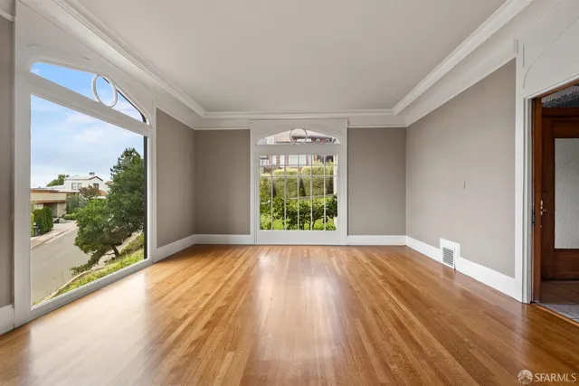 a view of empty room with wooden floor and fireplace