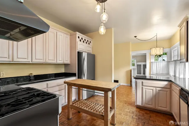 a kitchen with granite countertop a refrigerator a stove a sink and cabinets