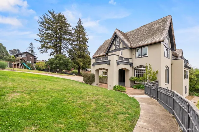 a front view of a house with yard and green space