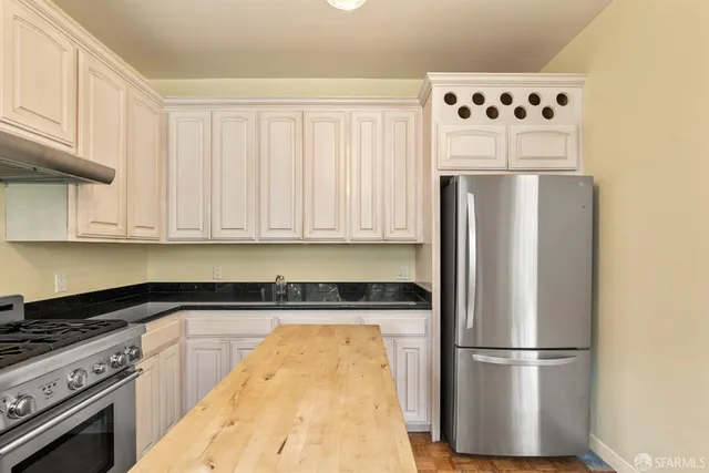 a view of an empty room with wooden floor fireplace and a window