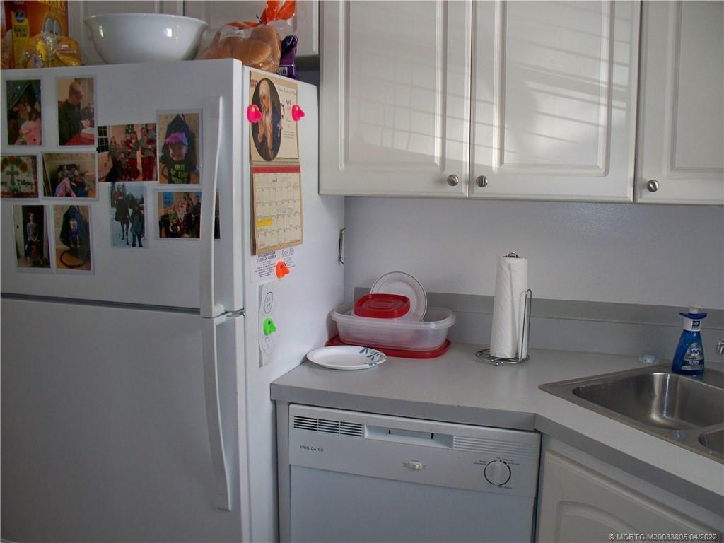 1913 Southwest Palm City Road, Unit 7B Stuart, FL 34994 - Photo 13 of 37 a kitchen with stainless steel appliances white cabinets and a refrigerator