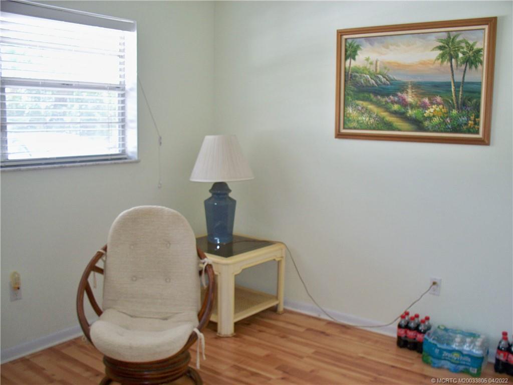 1913 Southwest Palm City Road, Unit 7B Stuart, FL 34994 - Photo 18 of 37 a room with a table and a painting on the wall