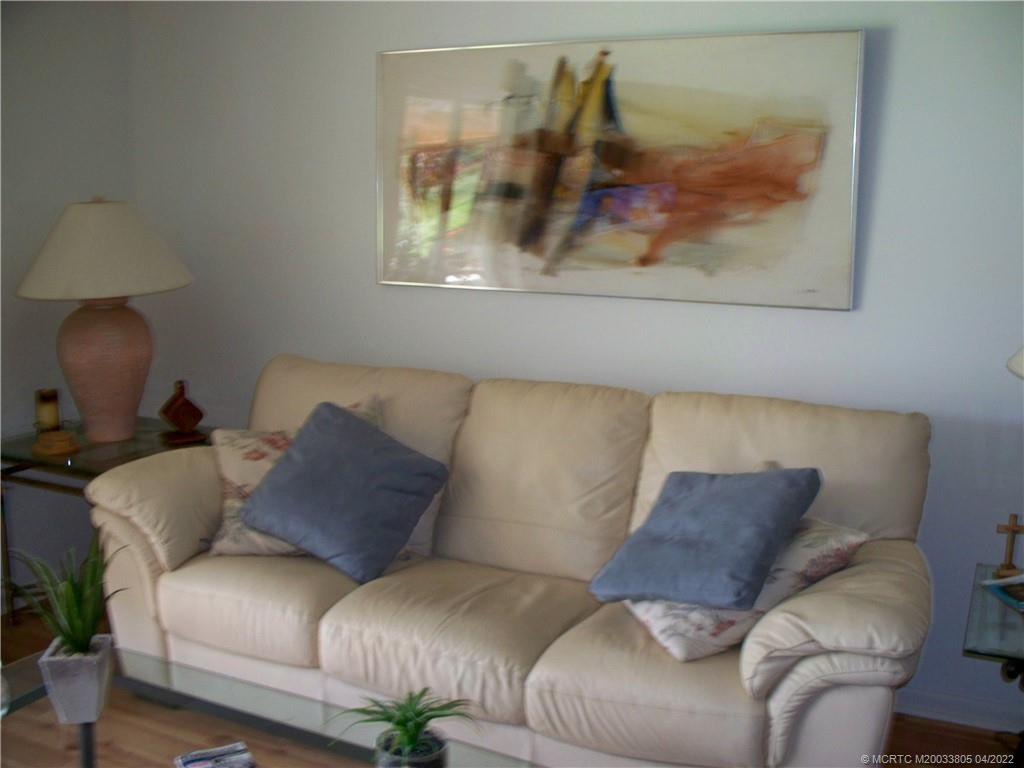 1913 Southwest Palm City Road, Unit 7B Stuart, FL 34994 - Photo 3 of 37 a living room with furniture and a painting on the wall
