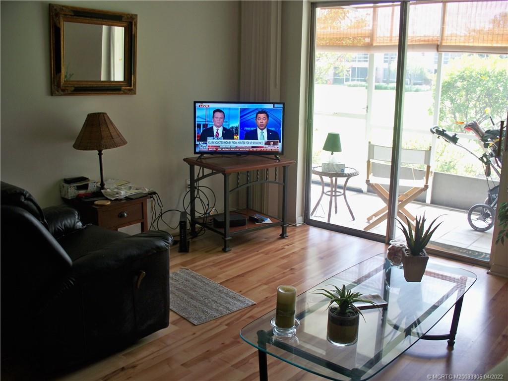 1913 Southwest Palm City Road, Unit 7B Stuart, FL 34994 - Photo 4 of 37 a living room with furniture and a flat screen tv with wooden floor