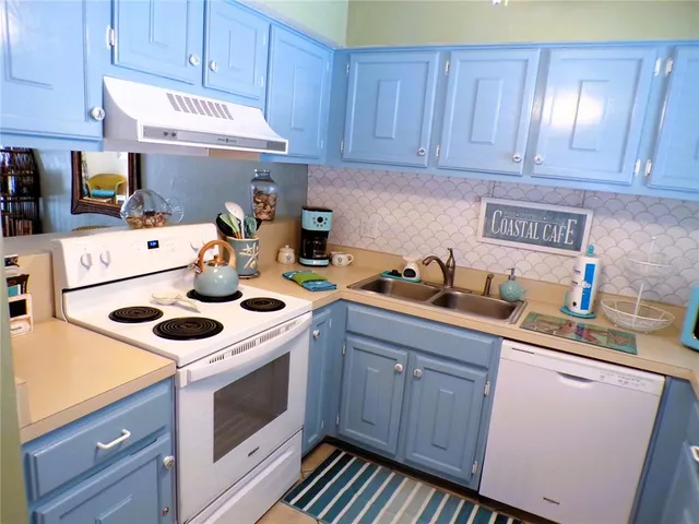 a kitchen with a sink a stove and cabinets