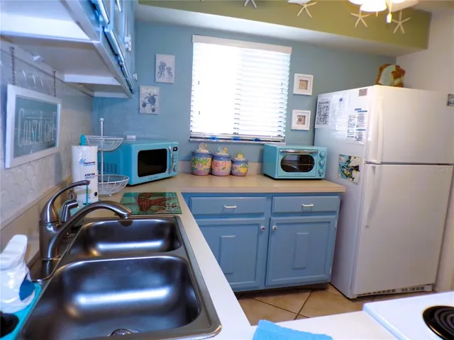 a kitchen with stainless steel appliances a refrigerator a sink a stove a counter space and a window