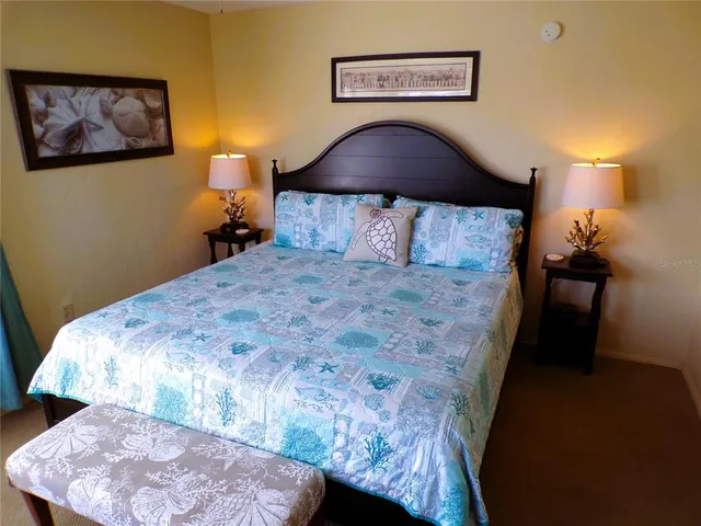 a bed sitting in a bedroom next to a lamp