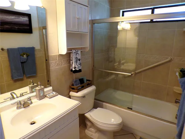a bathroom with a sink a toilet a mirror and shower
