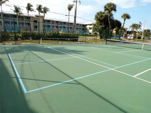 a view of a tennis ground with lots of buildings and trees