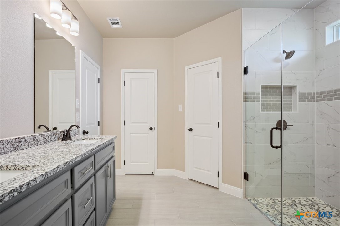 3824 Keller Road Temple, TX 76504 - Photo 18 of 28 a spacious bathroom with a granite countertop sink a mirror and shower