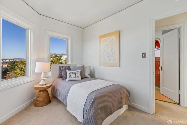 a bedroom with a large bed and a potted plant