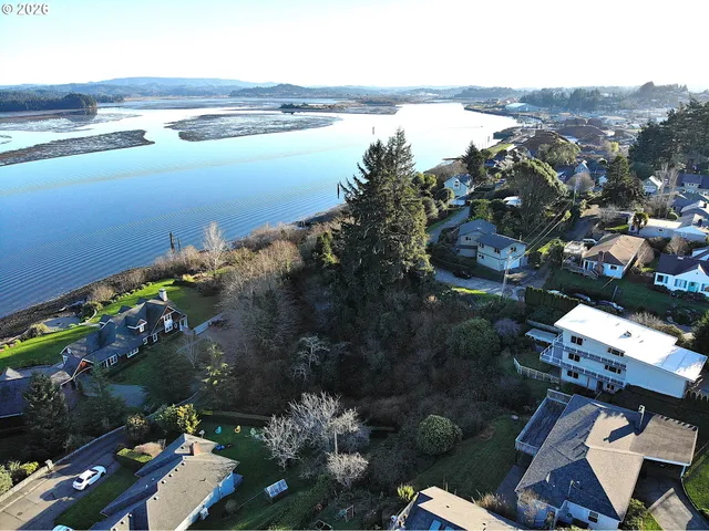 an aerial view of ocean and residential houses with outdoor space