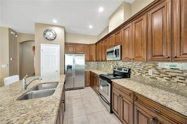 a kitchen with stainless steel appliances granite countertop a sink a stove and a refrigerator