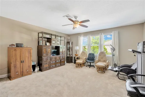 a living room with furniture a window and gym equipment